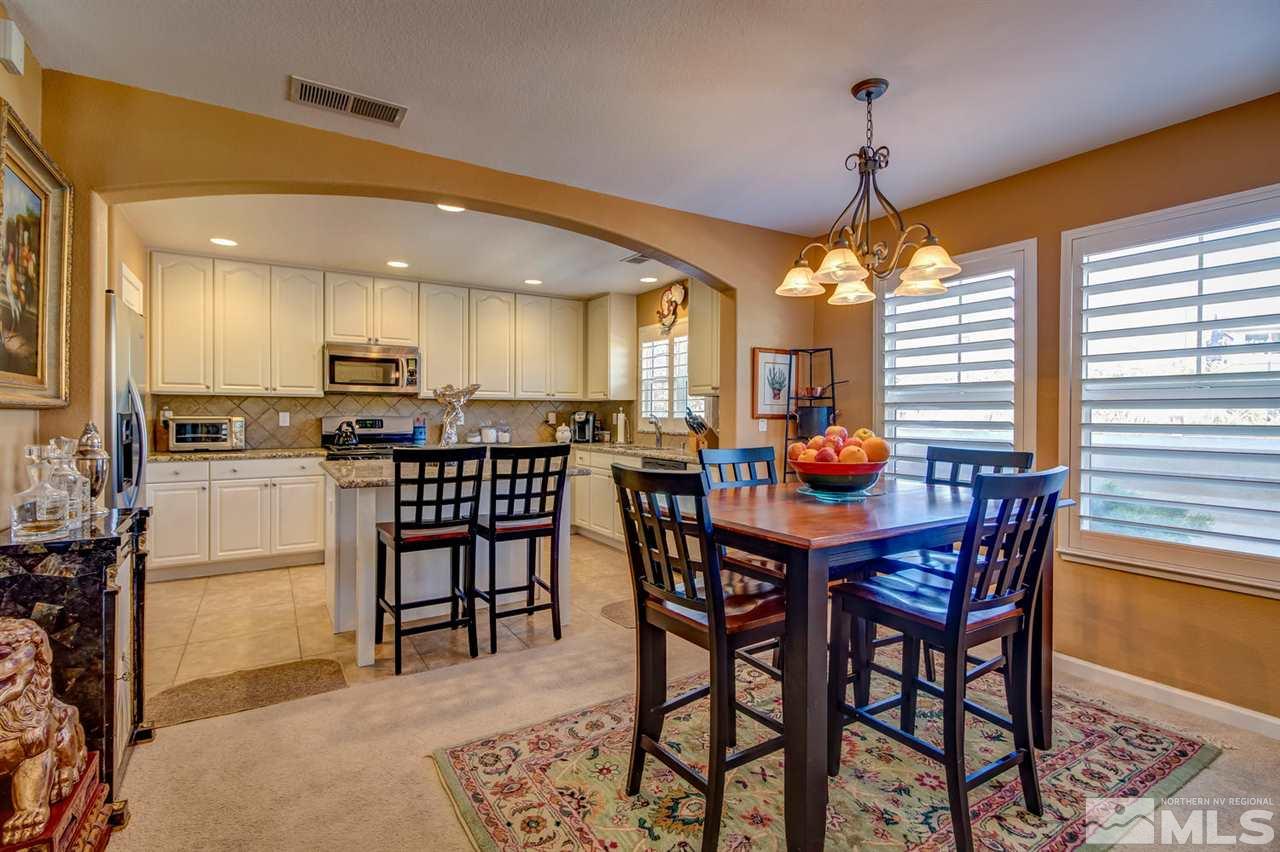 7675 Pebblestone Way Reno, NV 89523 - Photo 6 of 25 a dining room with stainless steel appliances kitchen island a table and chairs