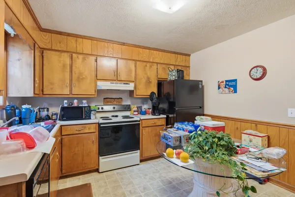 a kitchen with stainless steel appliances granite countertop a stove a sink and a refrigerator
