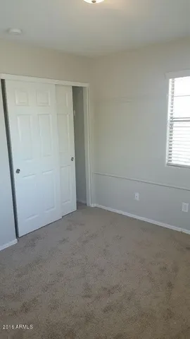 an empty room with windows and closet