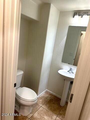 14039 West Country Gables Drive Surprise, AZ 85379 - Photo 7 of 32 a white toilet sitting next to a small sink