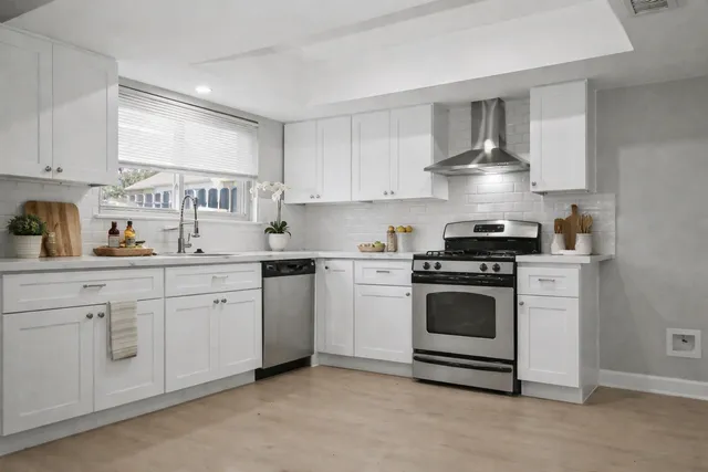 a kitchen with white cabinets and appliances