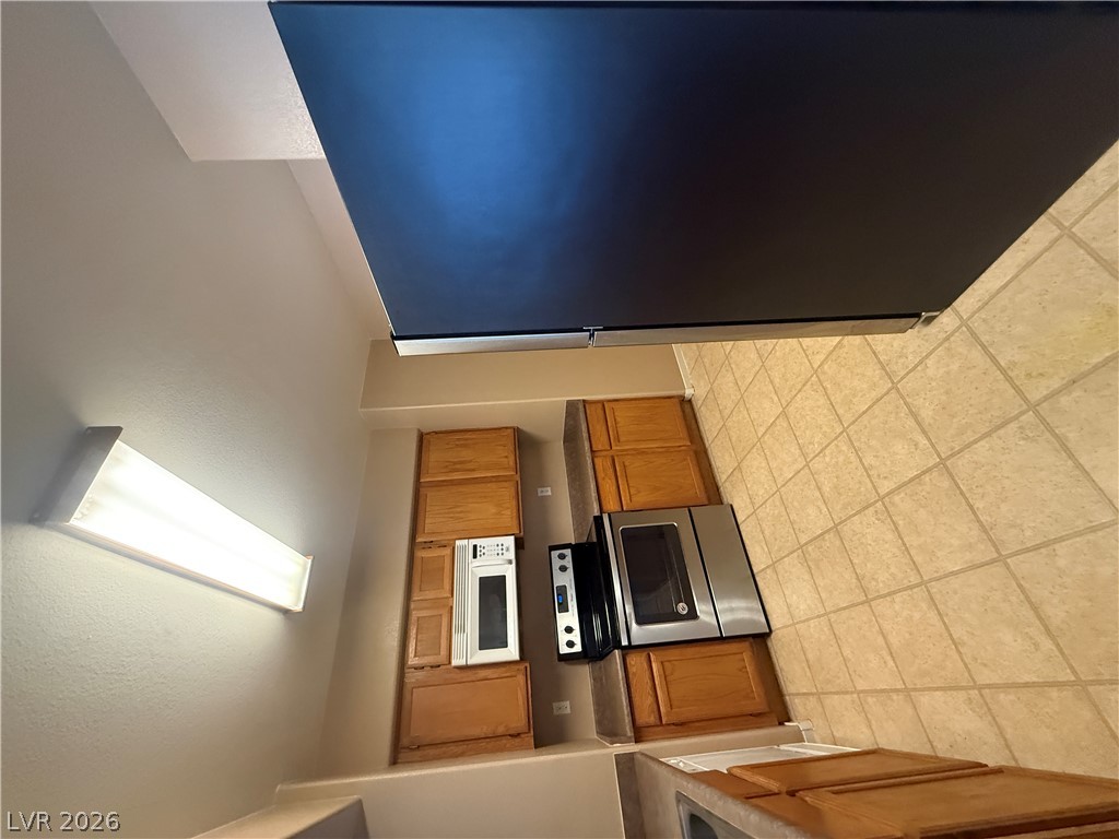 7255 West Sunset Road, Unit 2052 Las Vegas, NV 89113 - Photo 9 of 16 A compact kitchen boasts efficient appliances and warm wooden cabinetry.