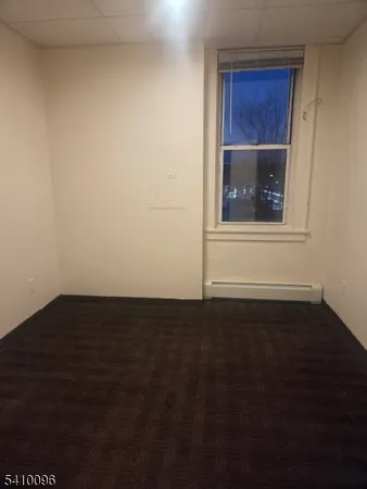 a view of an empty room and wooden floor and cabinet