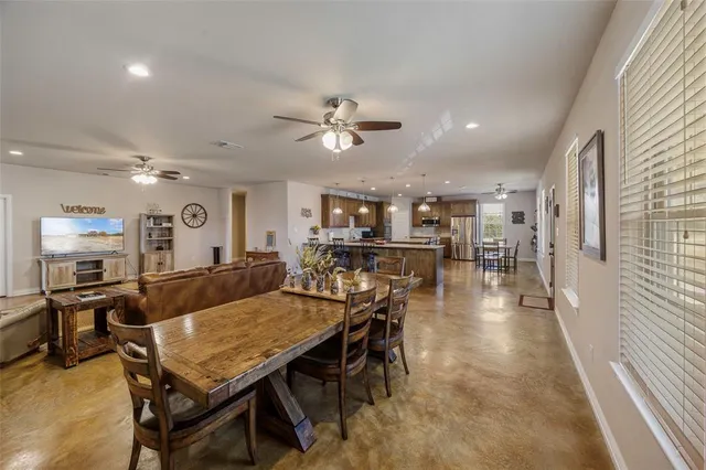 a dining hall with stainless steel appliances kitchen island granite countertop furniture and a kitchen view