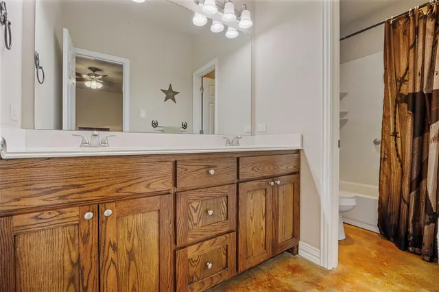 a bathroom with a granite countertop sink a mirror a vanity and a shower