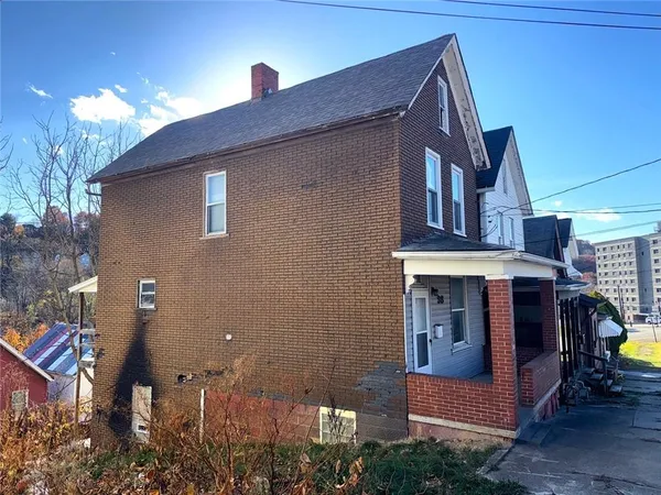 a front view of a house with barbeque grill and stairs