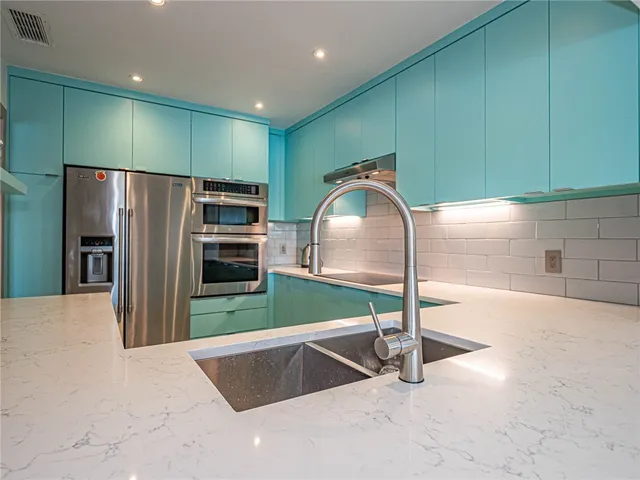 a kitchen with stainless steel appliances a refrigerator and a microwave