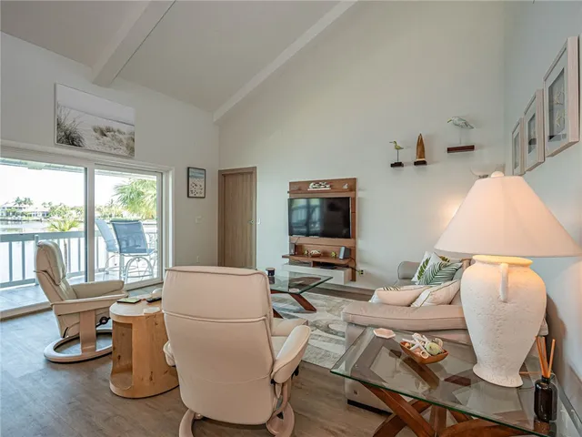 a living room with furniture a flat screen tv and a floor to ceiling window