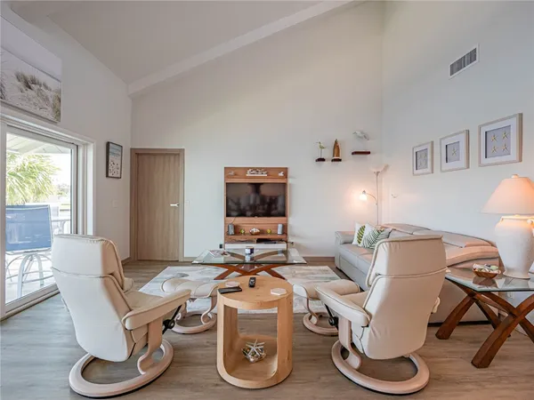 a living room with furniture a flat screen tv and a window