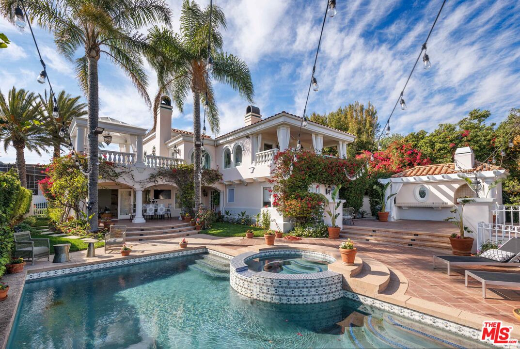 1100 Stradella Road Los Angeles, CA 90077 - Photo 12 of 26 a front view of a house with swimming pool and dining table and chairs