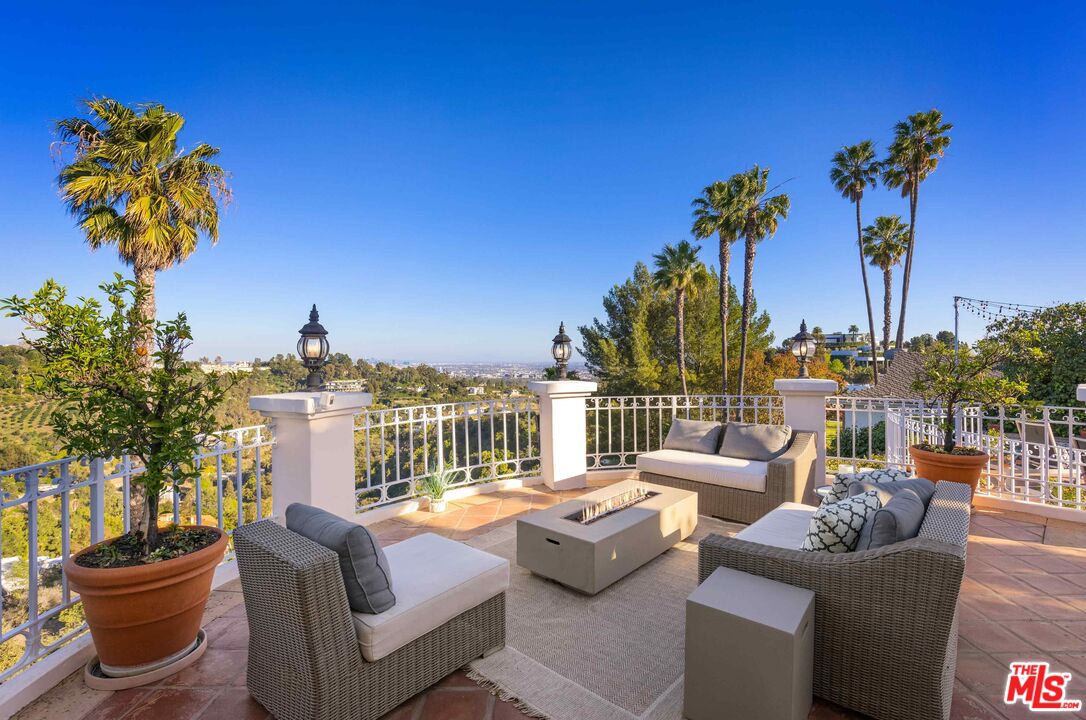 1100 Stradella Road Los Angeles, CA 90077 - Photo 14 of 26 a view of a patio with couches potted plants and city view