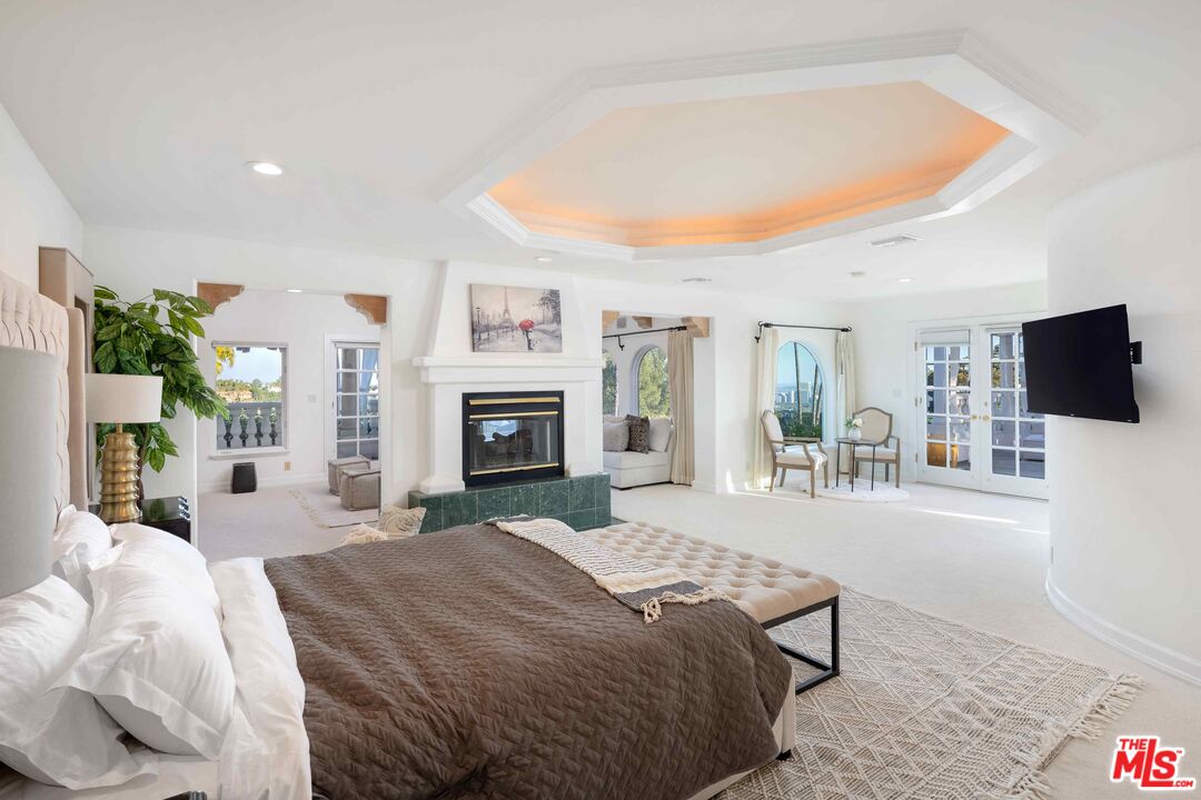 1100 Stradella Road Los Angeles, CA 90077 - Photo 16 of 26 a spacious bedroom with a bed and a flat screen tv