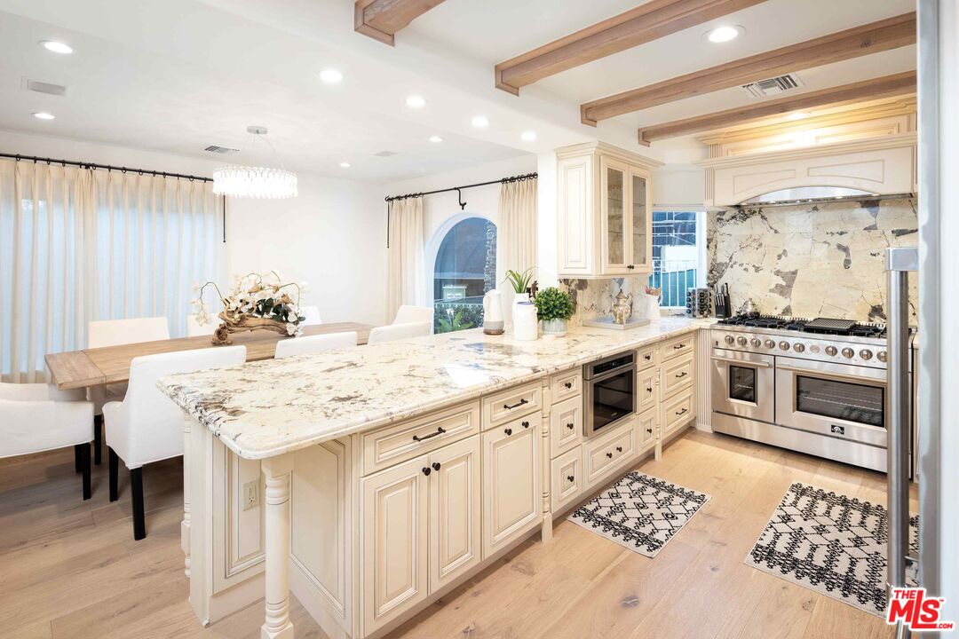1100 Stradella Road Los Angeles, CA 90077 - Photo 21 of 26 a kitchen with stainless steel appliances kitchen island granite countertop a sink and cabinets