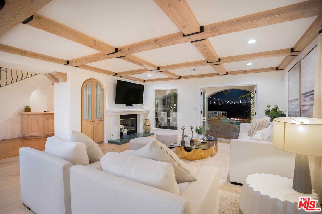 1100 Stradella Road Los Angeles, CA 90077 - Photo 22 of 26 a living room with furniture a fireplace and a flat screen tv