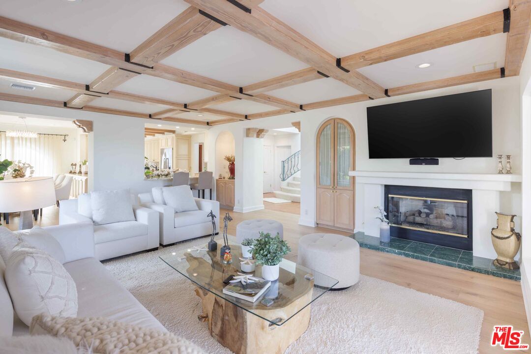 1100 Stradella Road Los Angeles, CA 90077 - Photo 5 of 26 a living room with furniture a fireplace and a flat screen tv