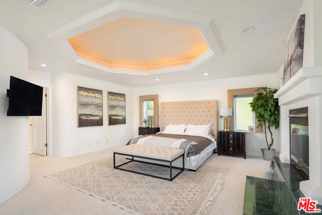 1100 Stradella Road Los Angeles, CA 90077 - Photo 9 of 26 a bedroom with a bed a flat screen tv and couches