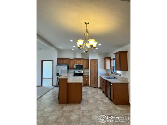 a living room with kitchen island granite countertop furniture and a chandelier