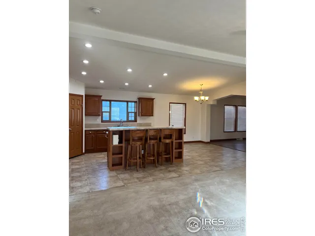 a open kitchen with kitchen island stainless steel appliances a dining table and chairs