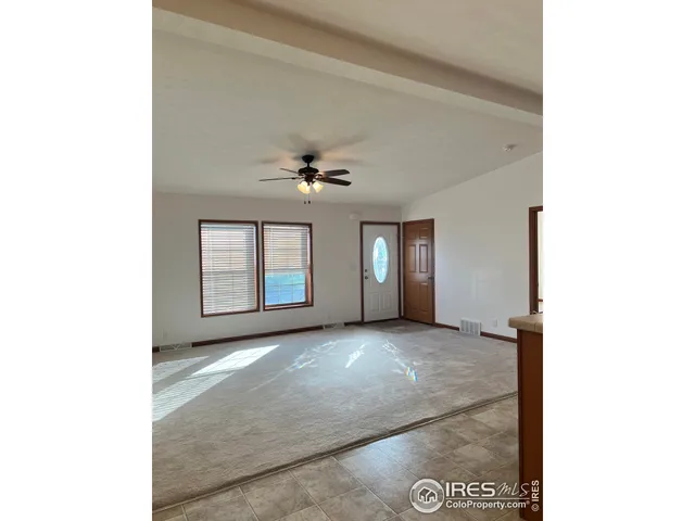 a view of a livingroom with a ceiling fan and window