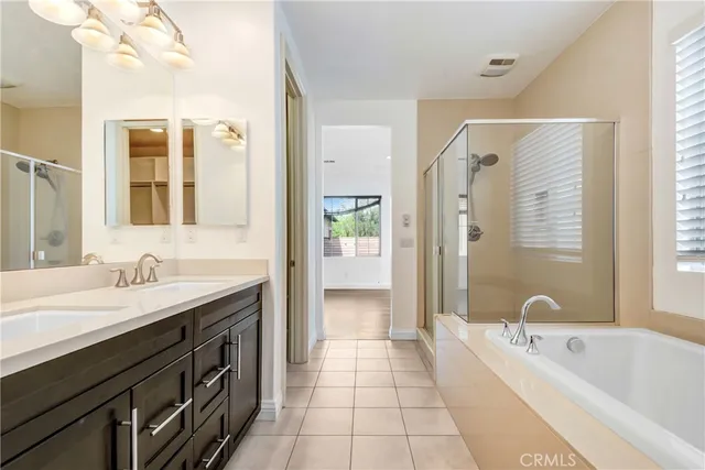 a spacious bathroom with a tub sink shower and a mirror