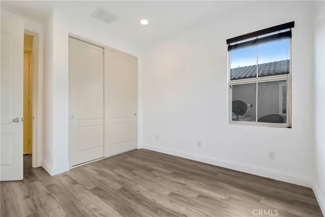 an empty room with wooden floor and closet