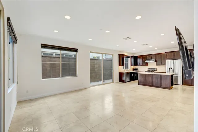 a large white room with kitchen view and a window