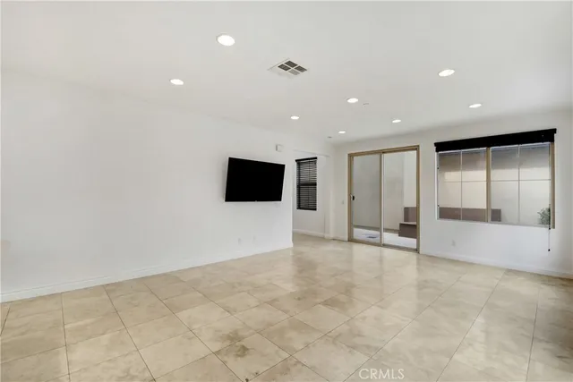 a view of an empty room with wooden floor and windows