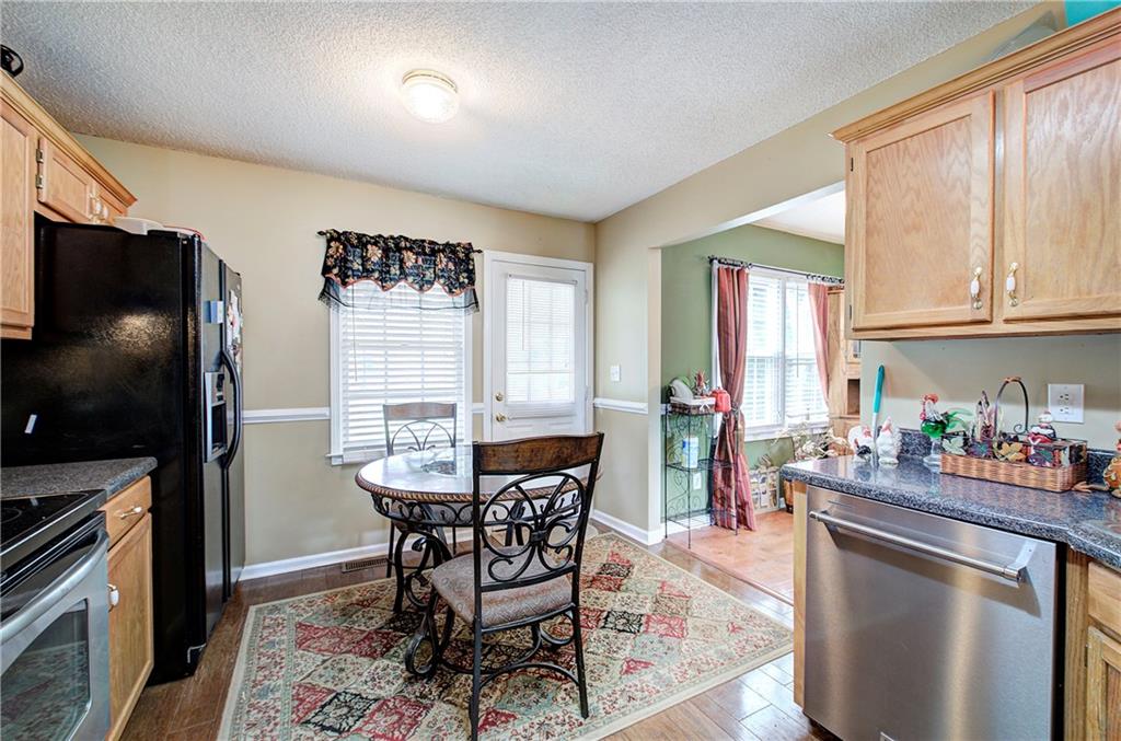 218 Gilreath Road Southeast Cartersville, GA 30121 - Photo 12 of 27 a kitchen with stainless steel appliances granite countertop a stove a refrigerator a sink a dining table and chairs with wooden floor