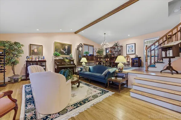 a living room with furniture and a dining table with wooden floor
