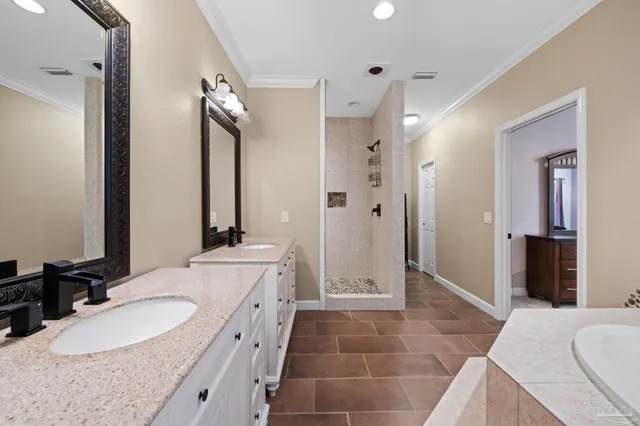 a bathroom with a granite countertop double vanity sink a mirror and a shower