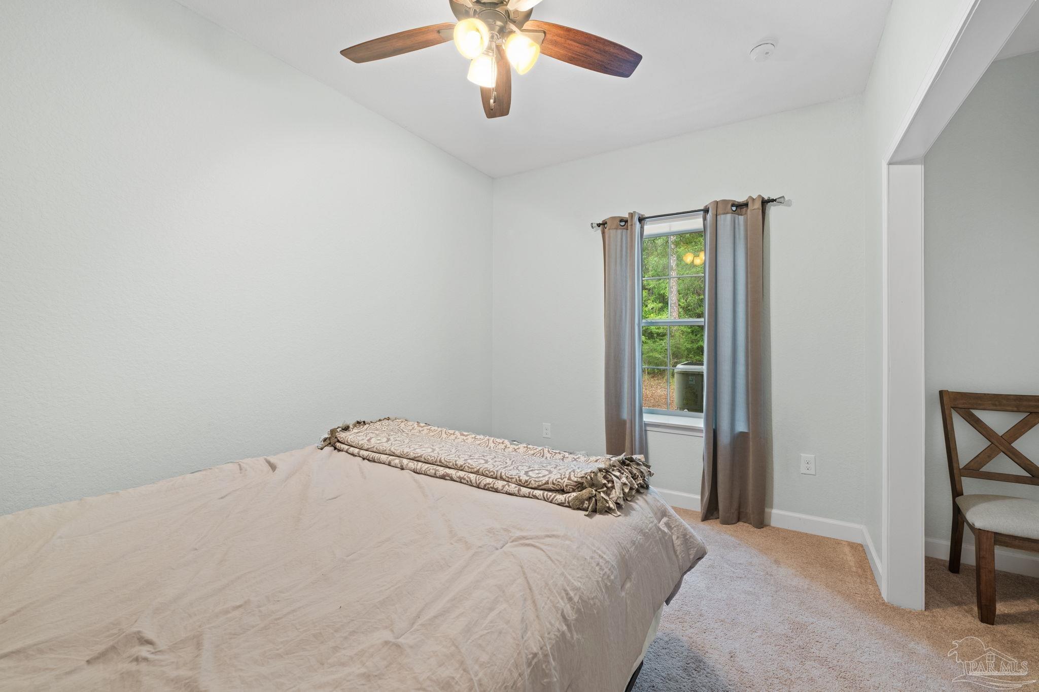 6781 Generals Lane Pace, FL 32571 - Photo 22 of 35 a bedroom with a bed and a chandelier