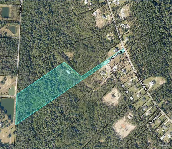 a view of a yard with plants and brick wall