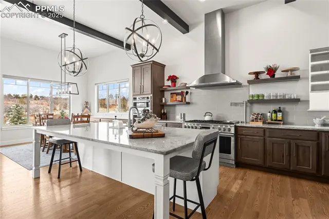 a kitchen with stainless steel appliances granite countertop a sink a stove and chairs