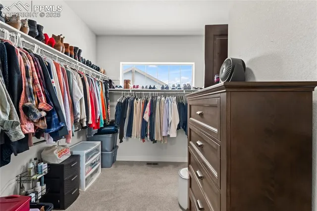 a view of walk in closet with clothes