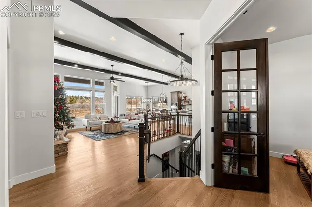 a living room with furniture large window and wooden floor