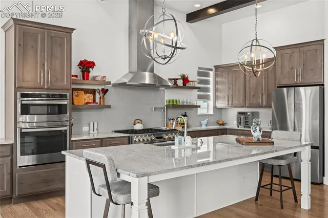 a kitchen with stainless steel appliances granite countertop a sink cabinets and wooden floor