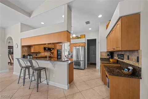 a kitchen with stainless steel appliances kitchen island granite countertop a table and chairs in it
