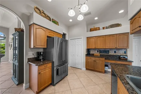 a kitchen with stainless steel appliances granite countertop a stove refrigerator and a sink