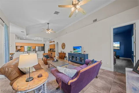 a living room with furniture a dining table and a chandelier