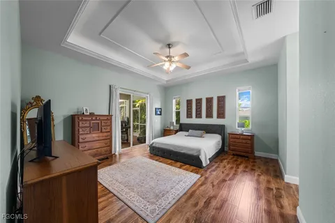 a bedroom with a bed and a flat tv screen on dresser