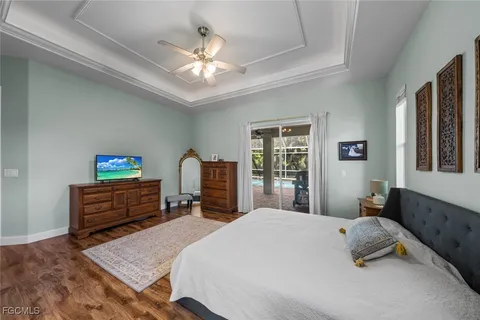 a bedroom with a bed and dresser with the outer view