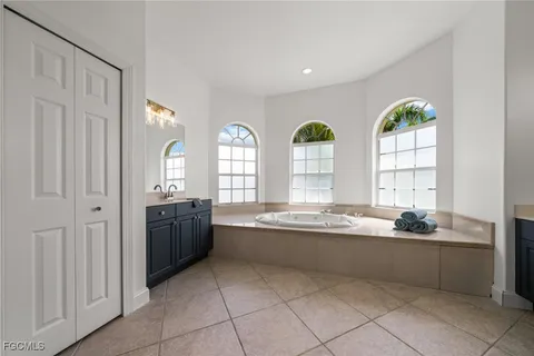 a large white kitchen with a large window and sink