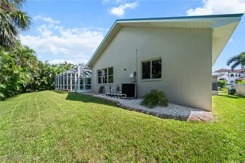 a front view of a house with a yard and palm trees