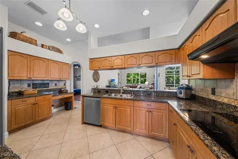a large kitchen with stainless steel appliances granite countertop a stove and large sink
