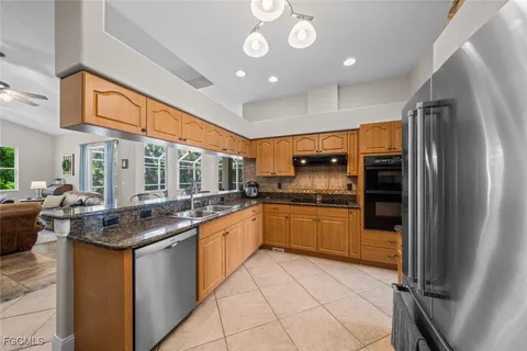 a kitchen with stainless steel appliances granite countertop a sink and a refrigerator