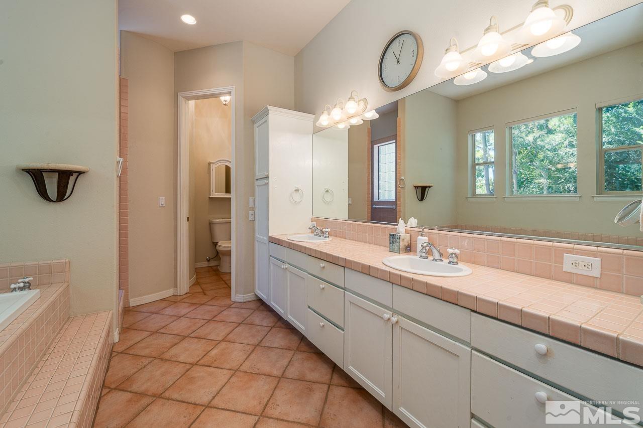 4440 Juniper Trail Reno, NV 89519 - Photo 17 of 29 a spacious bathroom with a granite countertop sink a mirror and a shower