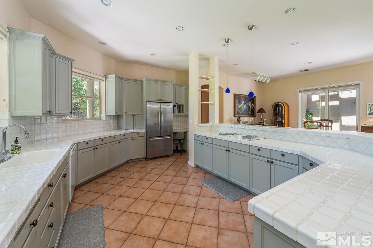 4440 Juniper Trail Reno, NV 89519 - Photo 10 of 29 a large white kitchen with a stove a sink a washer dryer and a refrigerator