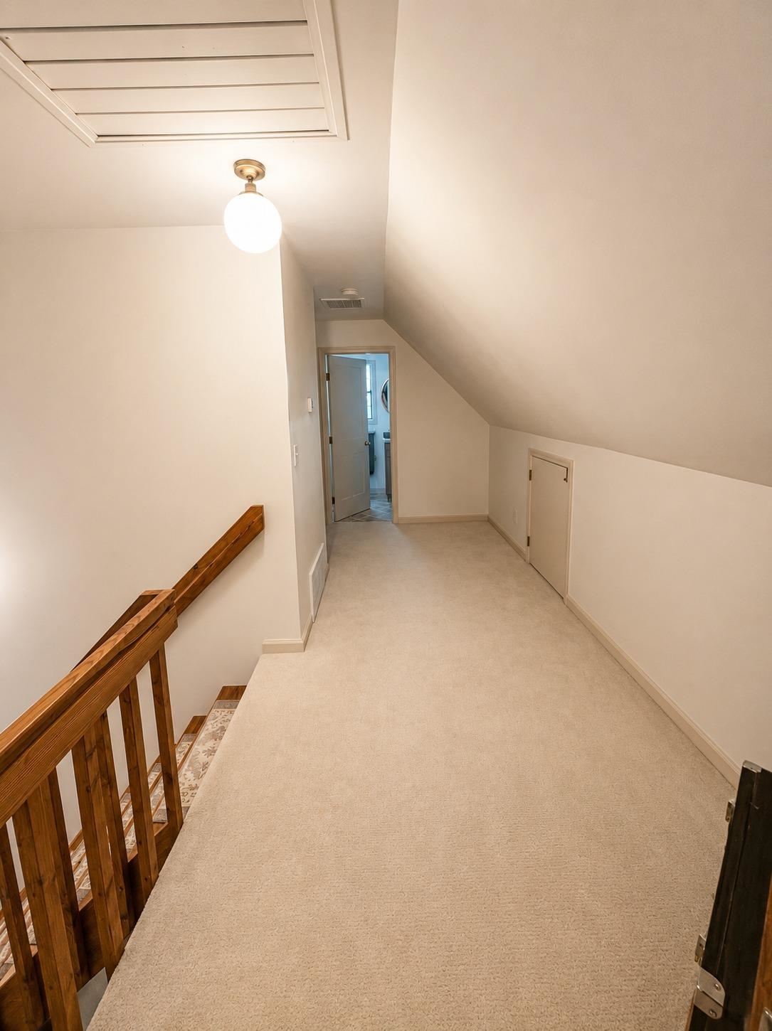 470 Rich Road Somerville, TN 38068 - Photo 37 of 40 Attic hallway featuring plush neutral carpeting, a wooden banister, and a sloped ceiling