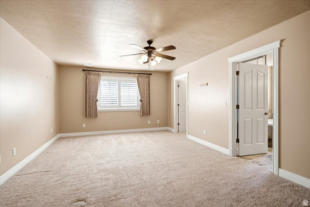 1089 West 2325th Street North Layton, UT 84041 - Photo 19 of 40 Spacious room featuring neutral carpeting, a ceiling fan with integrated lighting, and a window with white louvered shutters and drapes