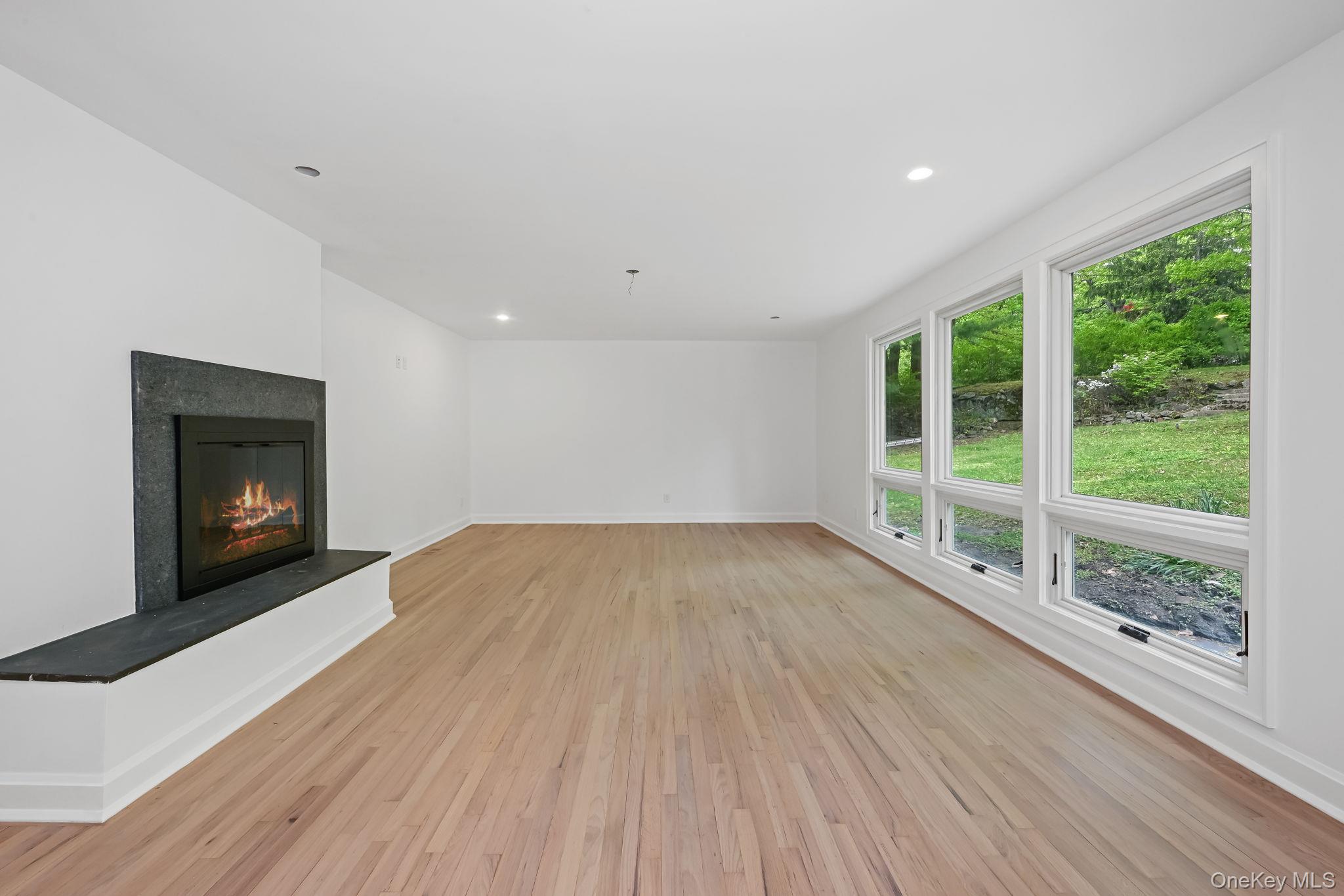 24 Country Road Mamaroneck, NY 10543 - Photo 10 of 37 a view of empty room with wooden floor and fireplace